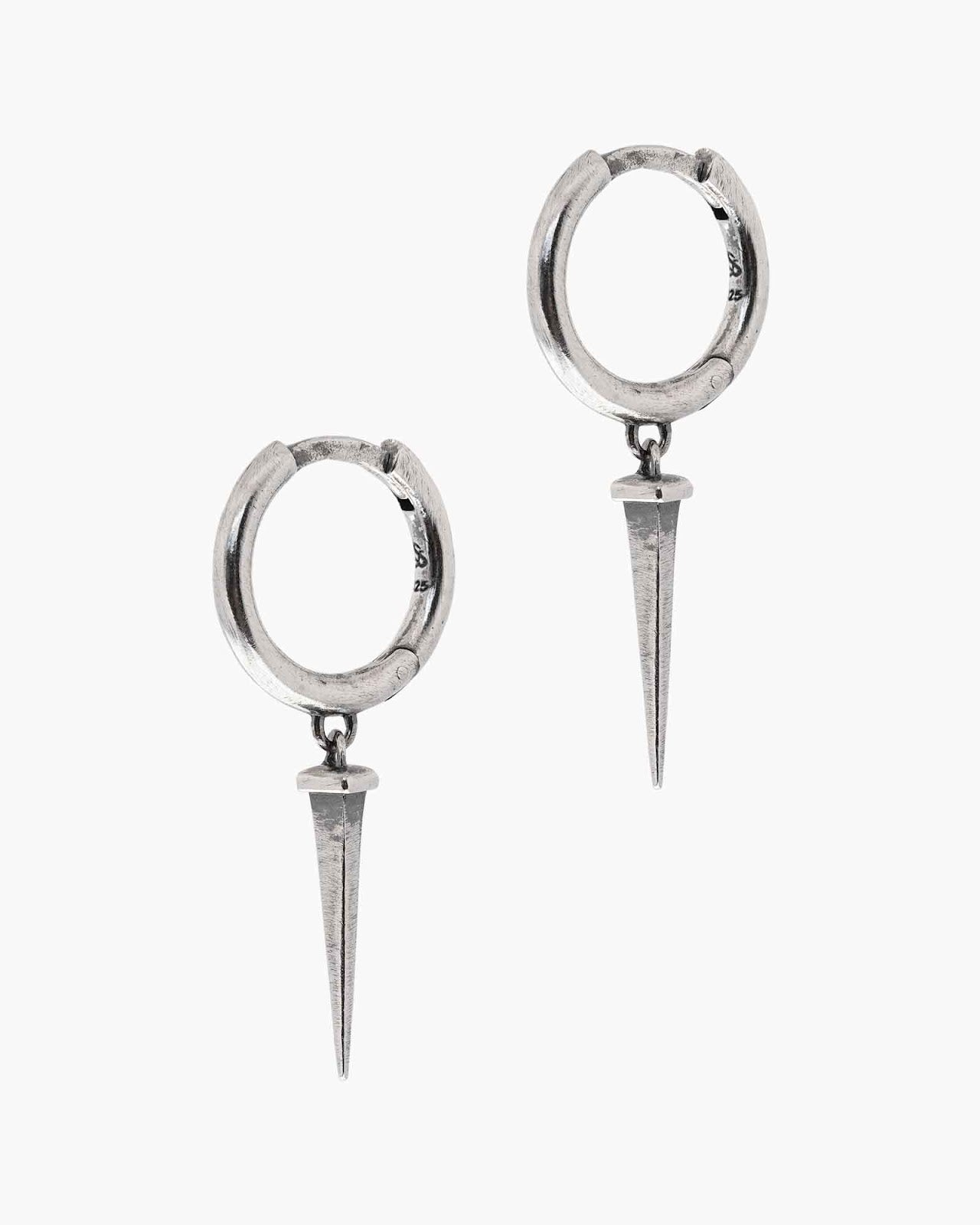 Pair of silver nail huggie earrings on a white background
