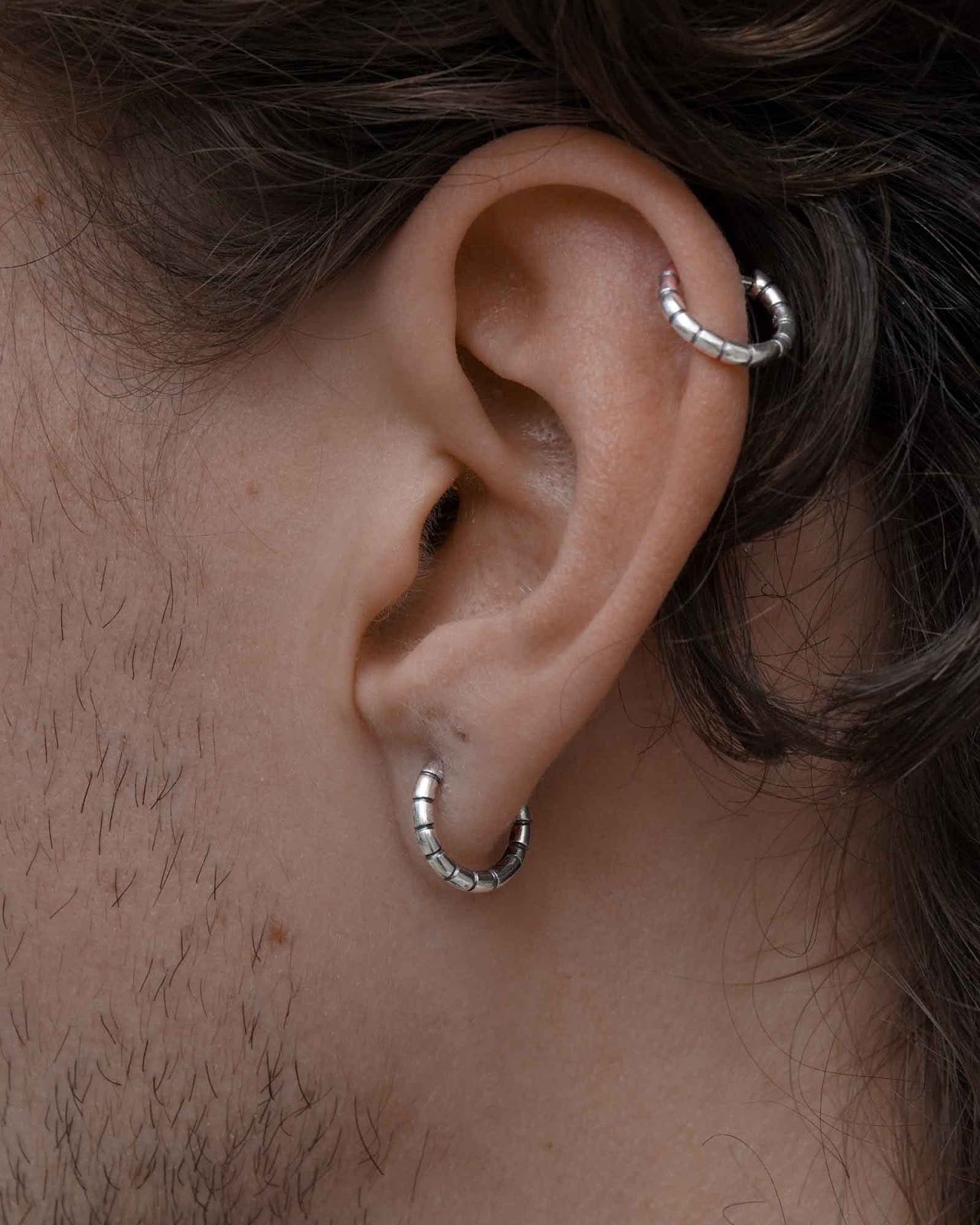 Close-up of a Bandi Huggie earring worn on the ear