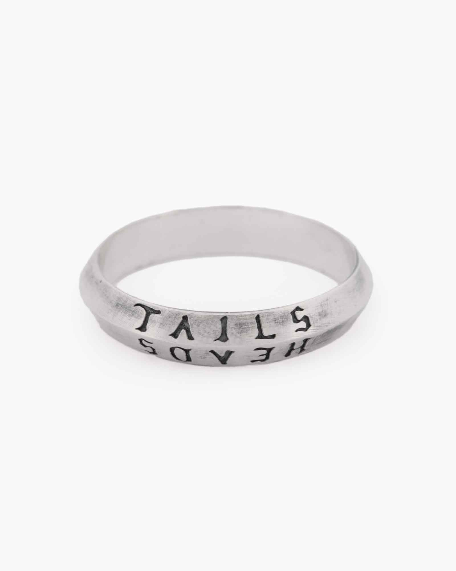 Silver ring with engraved text on a white background
