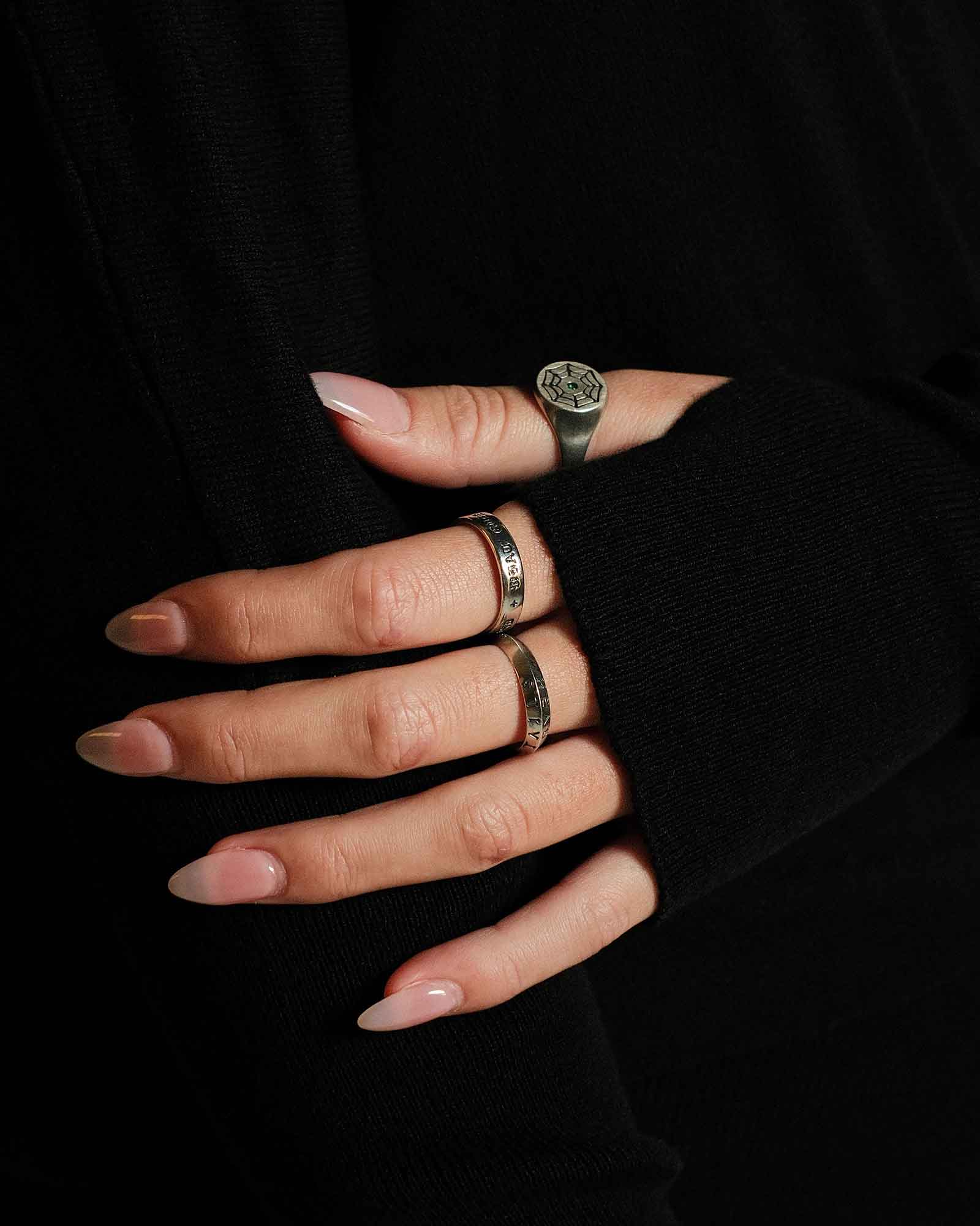 Hand with multiple rings on a black background