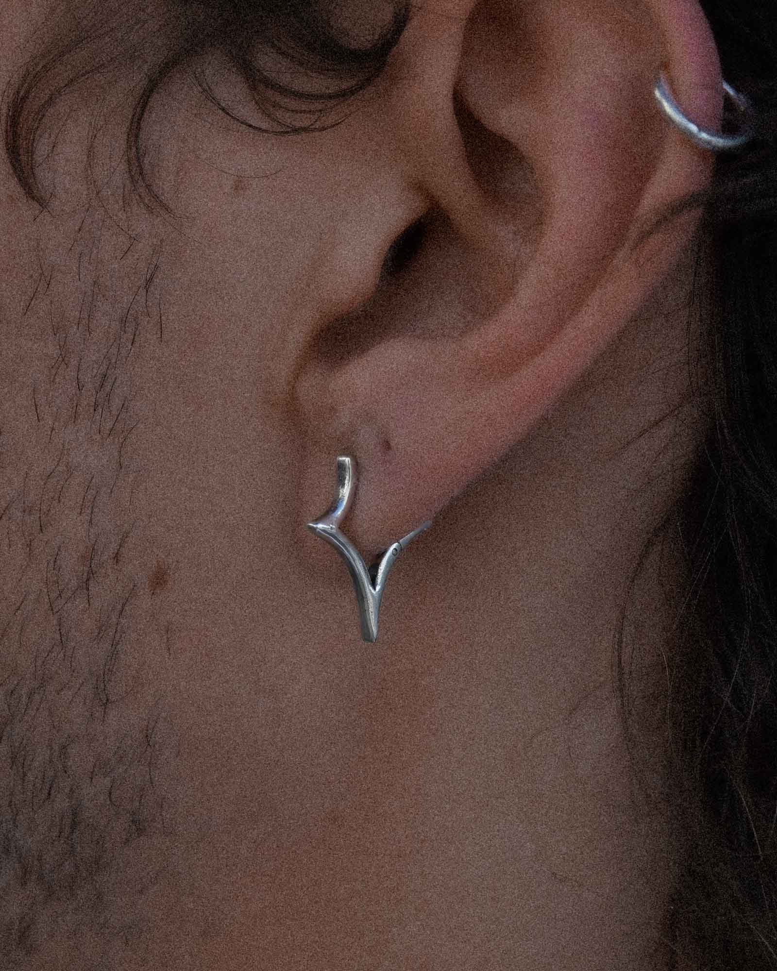 Close-up of an ear wearing a silver star shaped earring