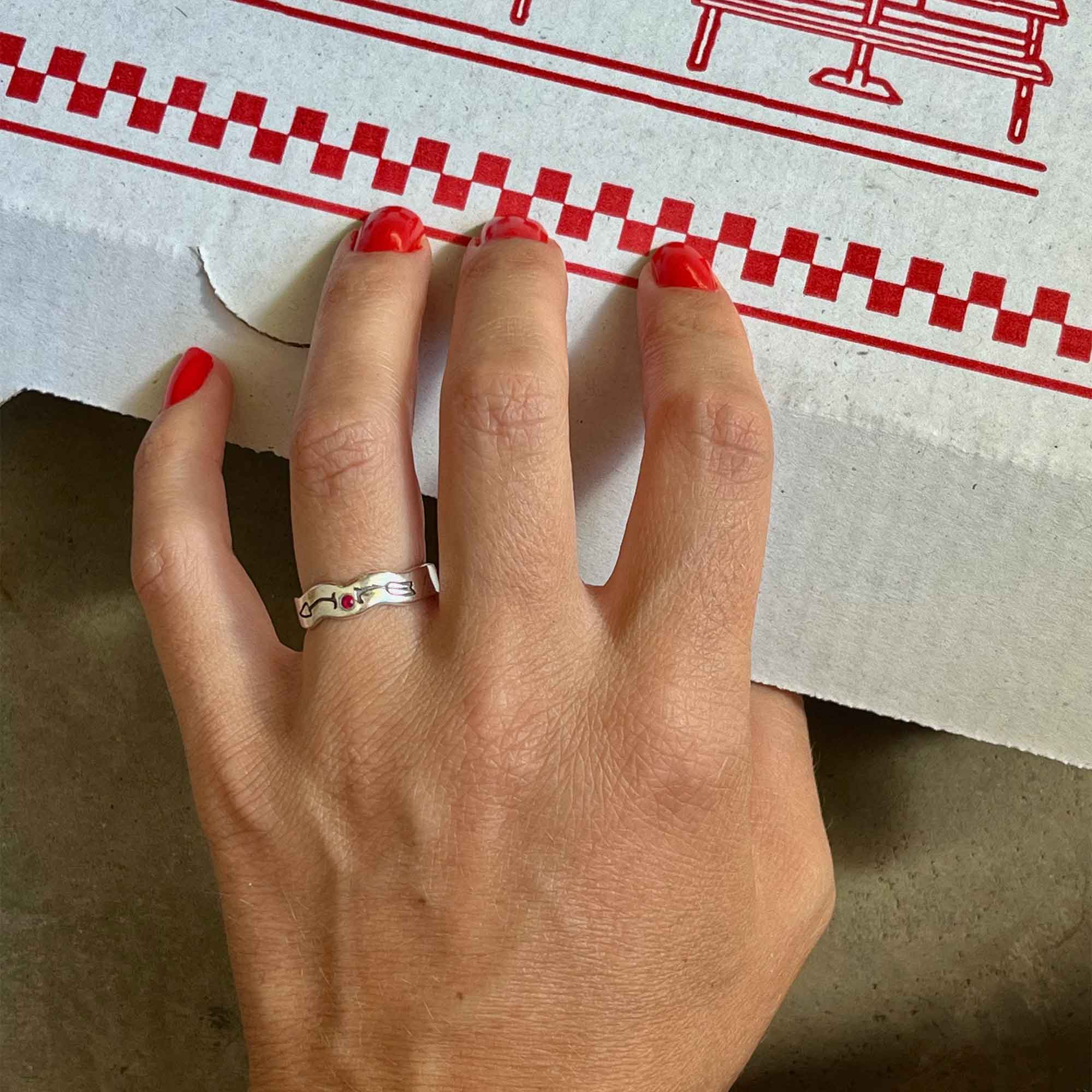 A Wavy 925 Silver Band Ring With An Arrow Engraving Encasing A Ruby Stone