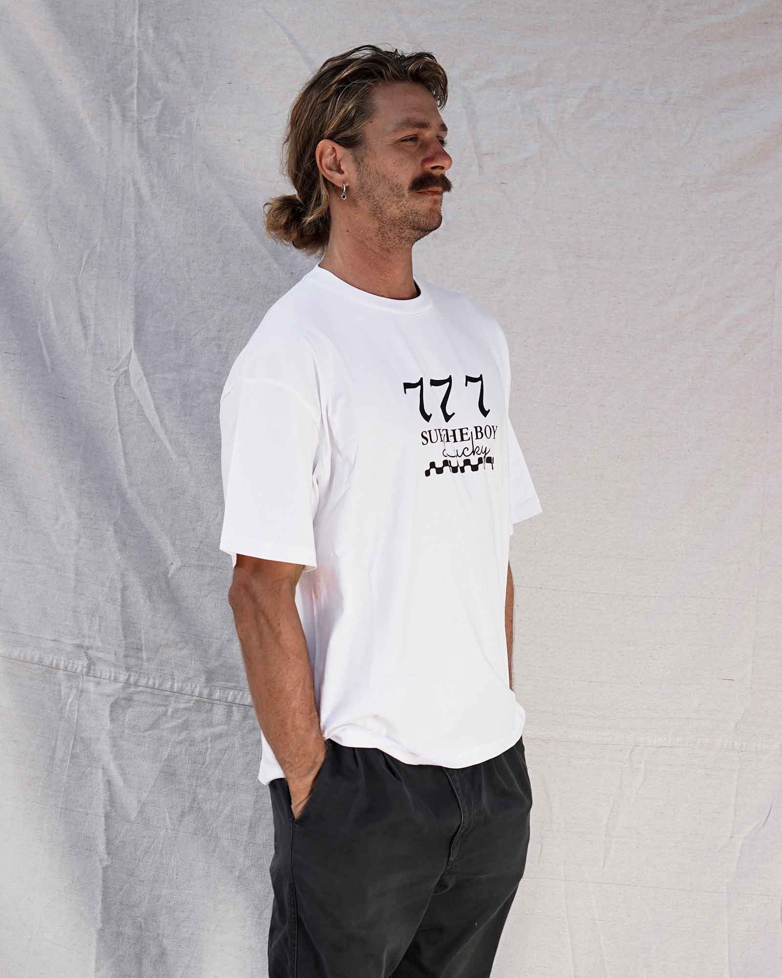 Man wearing a white t-shirt with text and graphics against a textured gray background