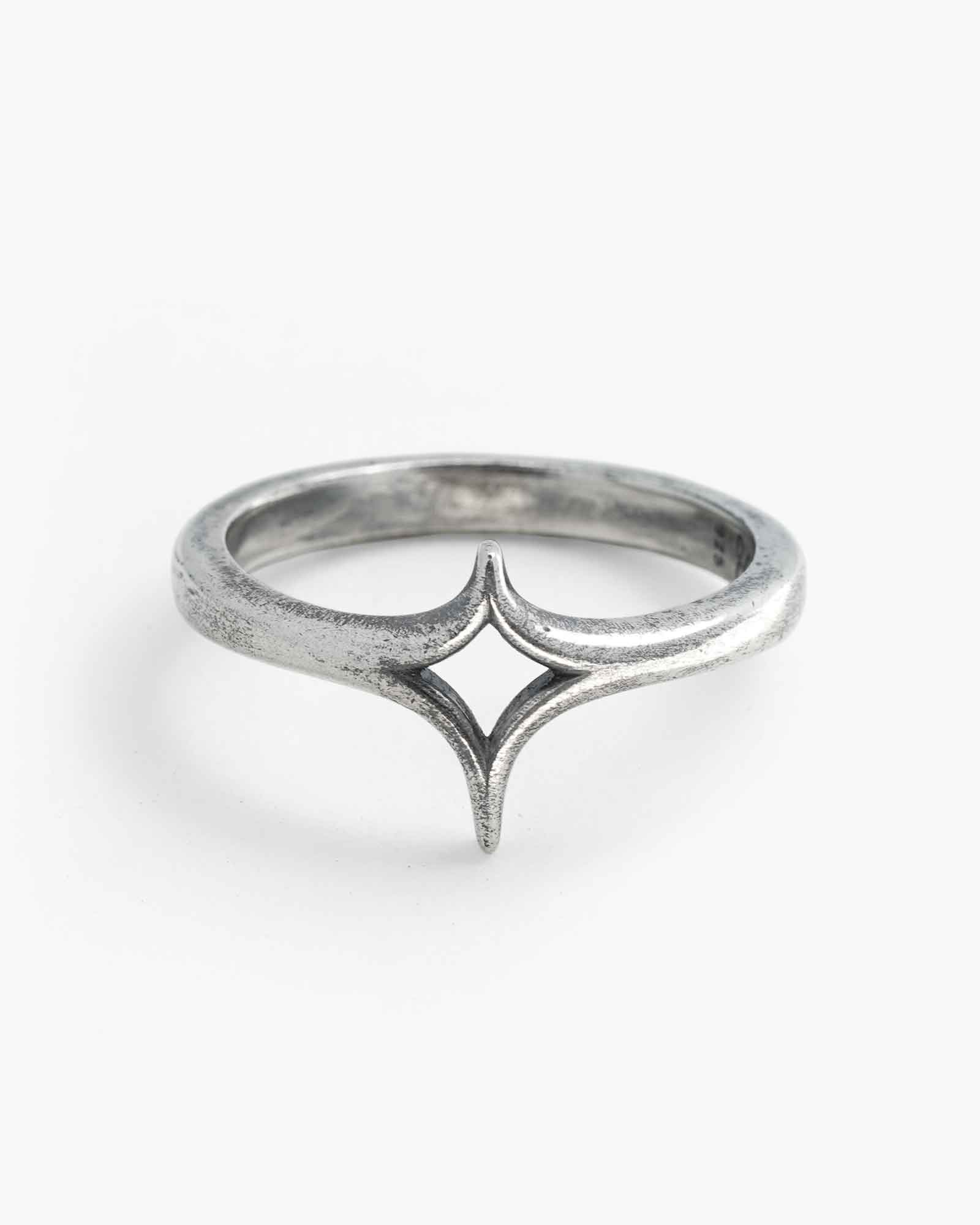 Silver ring with a star design on a white background
