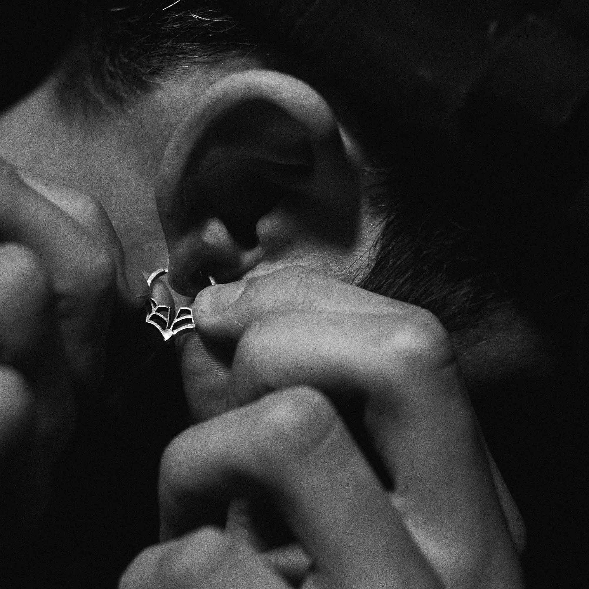 Person inserting an web huggie earring into their earlobe.