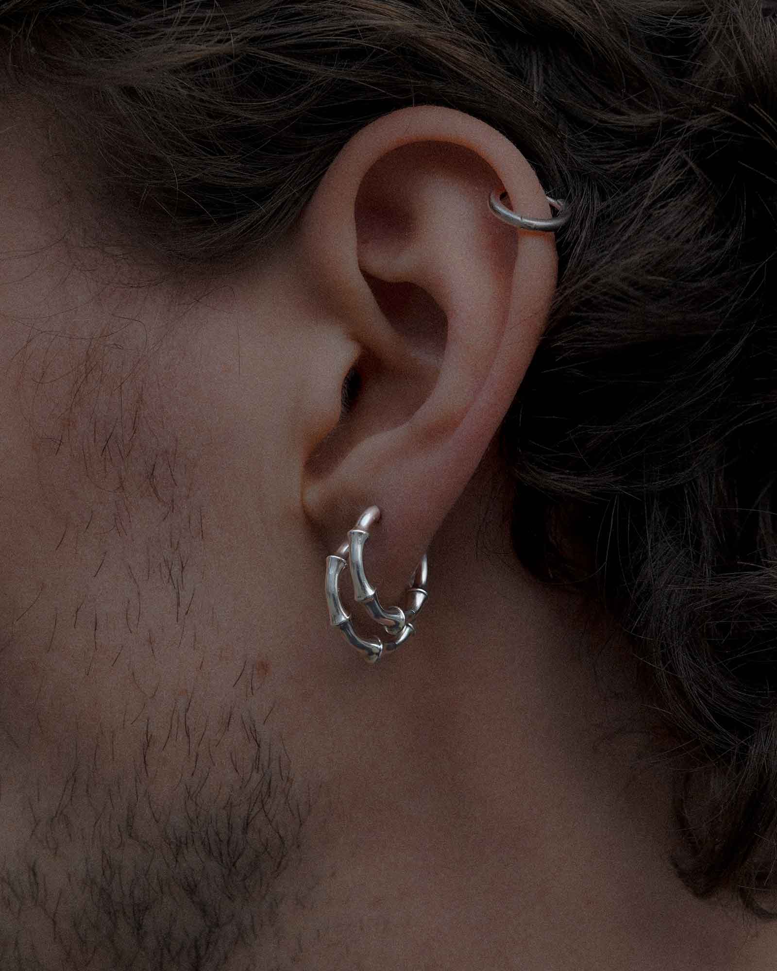 Close-up of an ear with a bone-shaped huggie earring