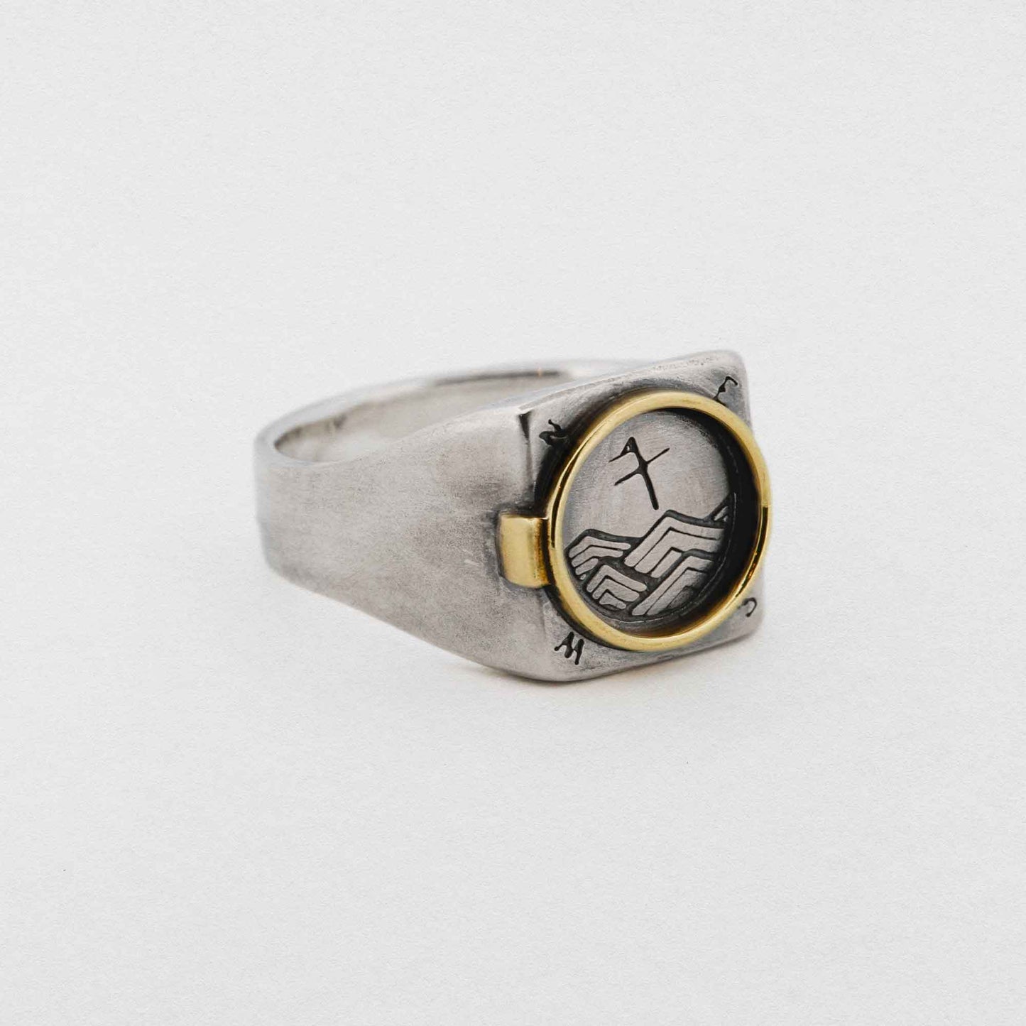A Silver Signet Ring With Brass Porthole Inlay